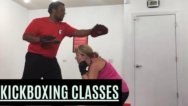 Boxing workout: Female ducking under punches. Male holding pads and throwing punches.
